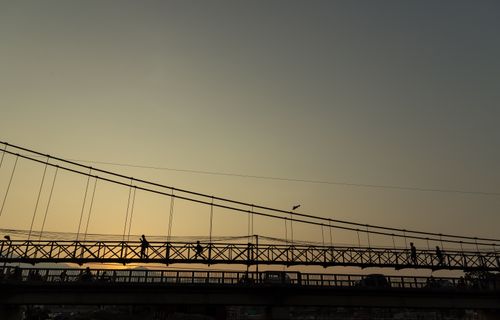 pedestrians,silhouetted,crossing,suspension,bridge,sunset,lalitpur,wednesday,february