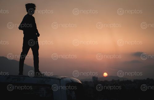 Find  the Image Man,cherishing,the,evening,moments,and,sun,about,to,set. and other Royalty Free Stock Images of Nepal in the Neptos collection.