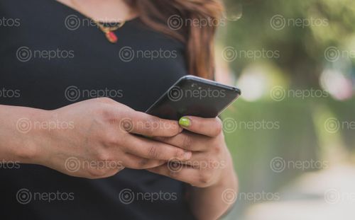 Find  the Image close,view,women,black,dress,typing,sms,mobile  and other Royalty Free Stock Images of Nepal in the Neptos collection.