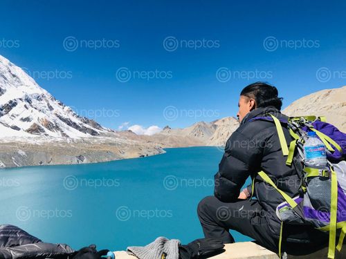 Find  the Image man,black,jacket,trekking,bag,enjoying,beautiful,view,tilicho,lake  and other Royalty Free Stock Images of Nepal in the Neptos collection.