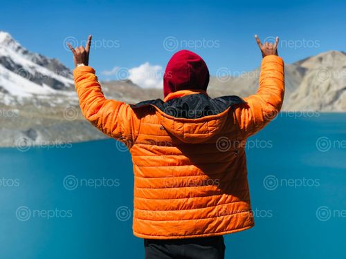 Find  the Image man,yellow,jacket,showing,rock,sign,viewing,magnificent,tilicho,lake  and other Royalty Free Stock Images of Nepal in the Neptos collection.