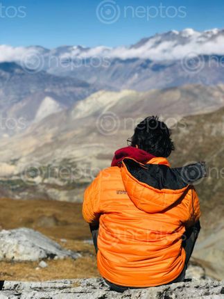 Find  the Image man,yellow,jacket,resting,enjoying,surreal,view,majestic,mustang,thorang,la,pass  and other Royalty Free Stock Images of Nepal in the Neptos collection.