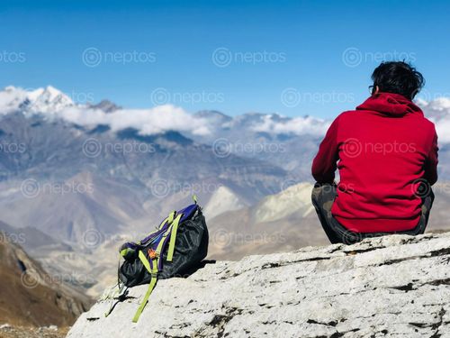 Find  the Image man,red,hoodie,resting,enjoying,surreal,view,mustang,thorangla,trial  and other Royalty Free Stock Images of Nepal in the Neptos collection.