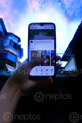 Find  the Image women,holding,mobile,watching,youtube,sky,background,photography  and other Royalty Free Stock Images of Nepal in the Neptos collection.