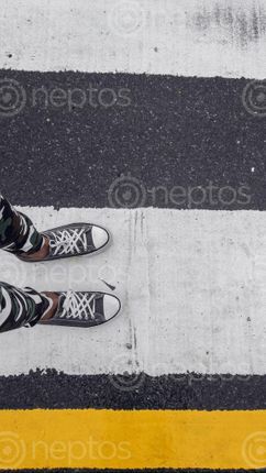 Find  the Image minimalist,picture,legs,boy,standing,white,part,zebra,crossing,bright,yellow,line,adding,contrast,image  and other Royalty Free Stock Images of Nepal in the Neptos collection.